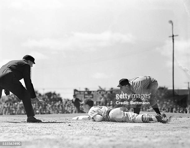 Stan Musial, St. Louis outfielder, slides safely into third base in the second inning of yesterday's exhibition game with the New York Yankees....