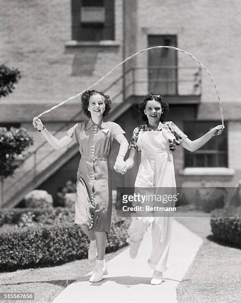 Team work with a jumping rope as well as in acting before the camera is displayed by Deanna Durbin and Judy Garland, two youngsters who are making...