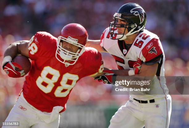 Tight end Tony Gonzalez of the Atlanta Falcons tries to fend off linebacker Matt Stewart of the Atlanta Falcons on a 12-yard run in the second...