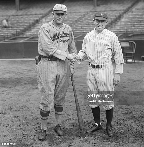 Photo shows Rogers Hornsby, left, manager of the St. Louis Cardinals, and Miller Huggins, manager of the New York Yankees, giving each other a...