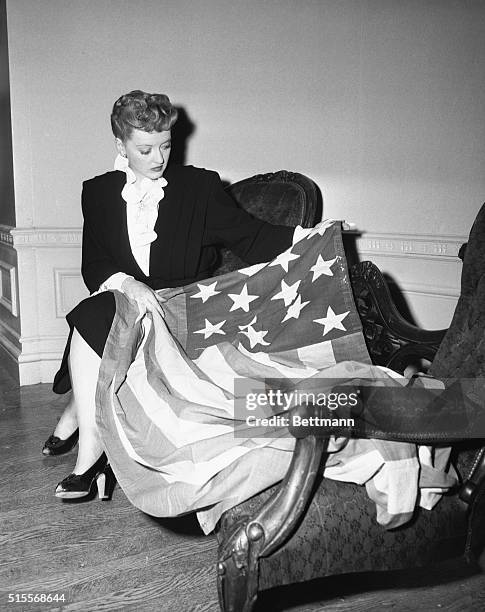 Screen actress Bette Davis holds this thirteen starred Revolutionary War Flag soon to be exhibited throughout the nation to aid in sale of war bonds....