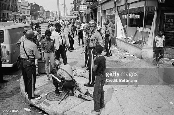 Police officers and National Guardsmen round up looters on a major thoroughfare following a second night of rioting in Newark, New Jersey. The...