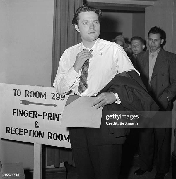 Orson Welles, the one man movie studio, adjusts his tie after the Army gave him a going-over and judged him "4-F" at the Los Angeles induction...