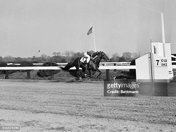 In this unusual photo showing all four hooves off the ground, Whirlaway with jockey George Woolf up, crosses the finish line to win the $10,000...