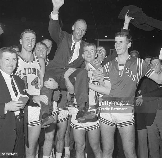 Coach Joe Lapchick is carried by jubilant players after St. John's won the ECAC Holiday Festival Basketball championship at Madison square Garden,...