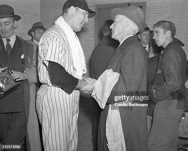 Judge Landis shakes hands with New York Yankee pitcher Charles "Red" Ruffing after the Yankees lost the final World Series to the St. Louis Cardinals.