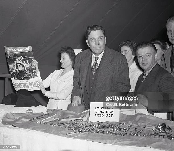 New York City: For Emergencies. Wendell Willkie and David Dubinsky, president of the ILGWU, look over an emergency operation set in a field tent...