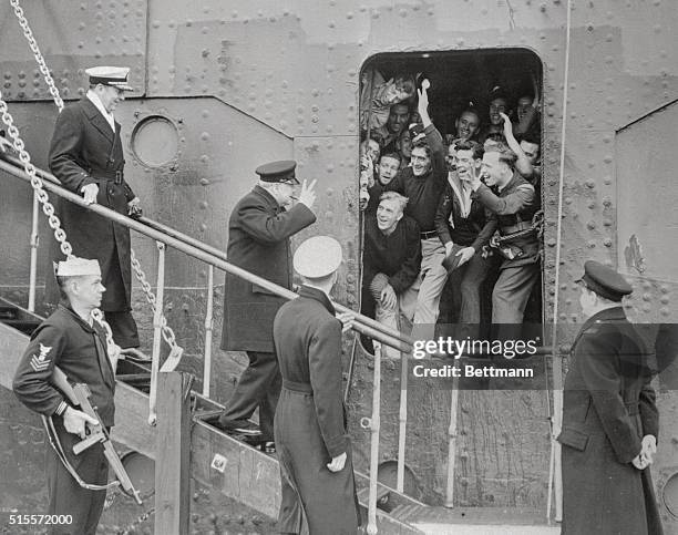 British Prime Minister Winston Churchill giver the victory sign as he receives the good wishes of the sailors and Airmen upon disembarking from the...