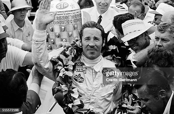 Italian-born Mario Andretti of Nazareth, Pennsylvania, is bedecked with flowers after winning the Indianapolis 500-mile race at Indianapolis speedway...