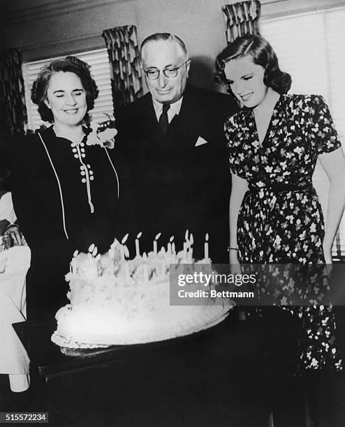 Louis B. Mayer head of MGM, presents Judy Garland with a birthday cake, while her mother looks on.