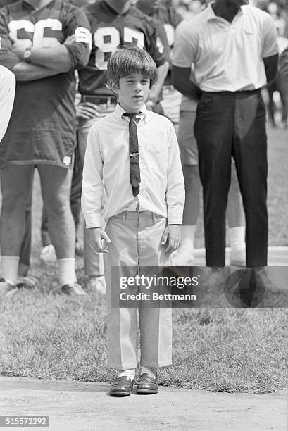 Eight-year-old John F. Kennedy Jr. Surveys the ceremonies as he stands before a group of football players in the stadium being formally dedicated to...