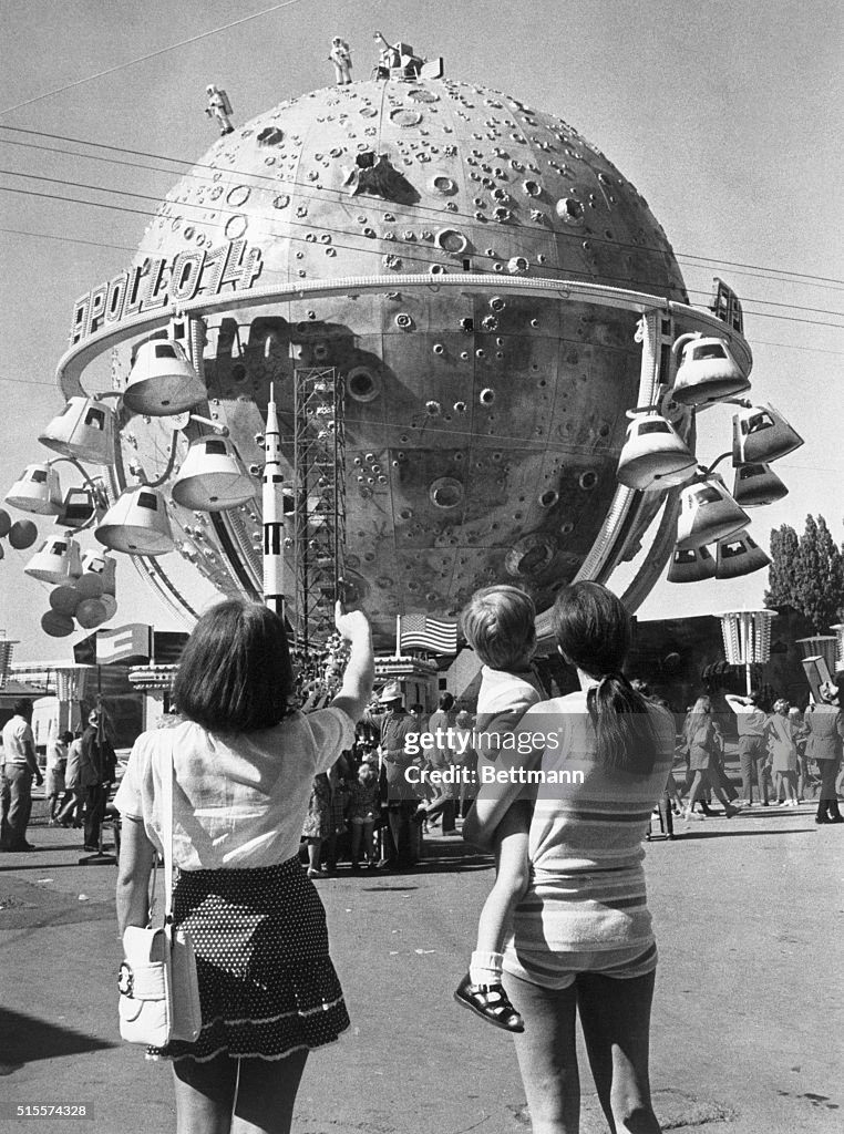 Space Moon Ride Two women with a child watch the moon ride