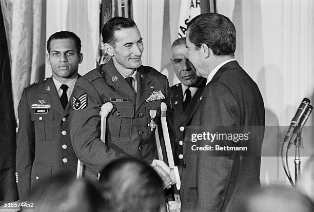 Pres Nixon congratulates Air Force T/Sgt. Leroy Wright, of Little Falls, Minn., after presenting him with the Air Force Cross at the White House...