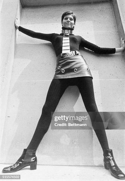 Fashion model wears a black wool jersey, black wool tights, and a black leather mini-miniskirt from Pierre Cardin's fall collection of 1969,...