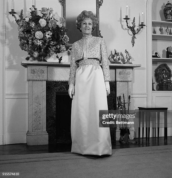 New York: In her apartment here, Mrs. Pat Nixon models the Harvey Berin gown she will wear to the Inaugural Ball in Washington Jan. 20th. The mimosa...