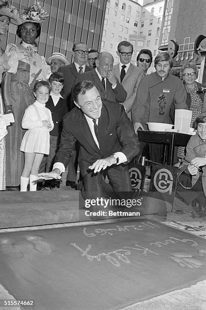 Hollywood, Calif.:Motion picture star and director Gene Kelly smiles after placing his handprints in cement in the forecourt of the Grauman's Chinese...