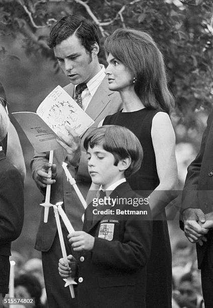 Jacqueline Kennedy Onassis stands with her son John at a memorial mass at the gravesite of Senator Robert F. Kennedy, on the year anniversary of his...
