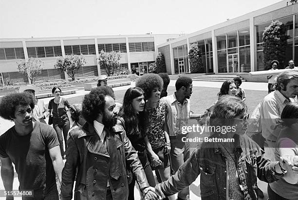 Angela Davis is accompanied by her friend, Victoria Machado, and a retinue of bodyguards June 4th, as she leaves courtroom after the jury acquitted...