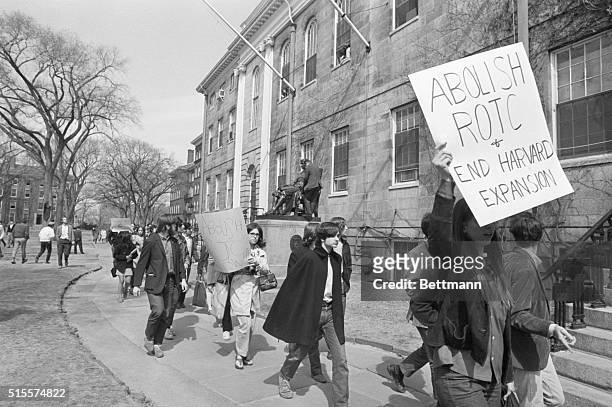 Students demonstrating at Harvard University 4/9 march past the statue of John Harvard en route to taking over University Hall...the building at...
