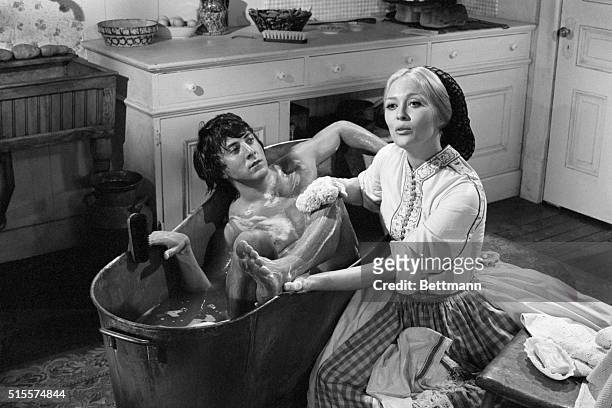 Actress Faye Dunaway looks stern as she hand-bathes Oscar nominee Dustin Hoffman during the filming of a scene from their first movie together,...