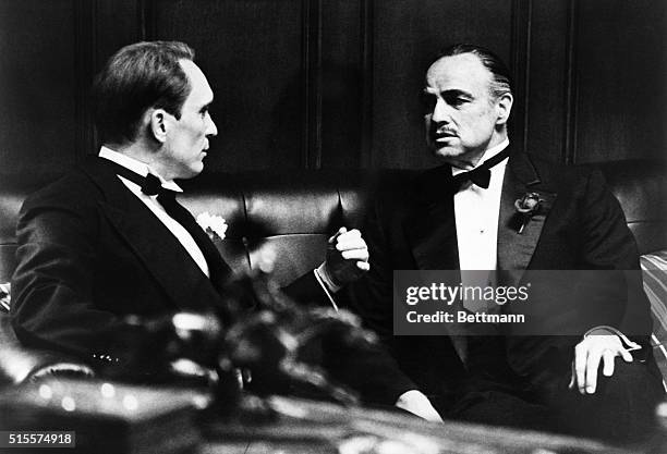 While his daughter's wedding celebration proceeds outside, Don Corleone, played by Marlon Brando , discusses "family" business with his consigliori,...