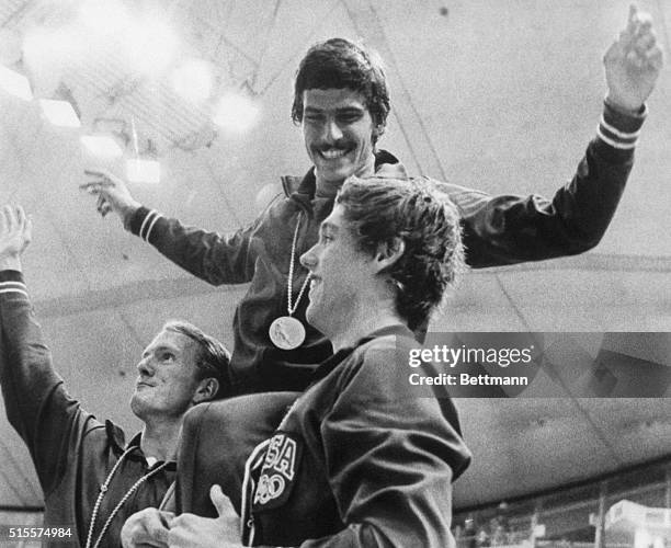 American swimmers Tom Bruce and Mike Stamm carry teammate Mark Spitz on their shoulders during the medal ceremony for their victory in the men's...