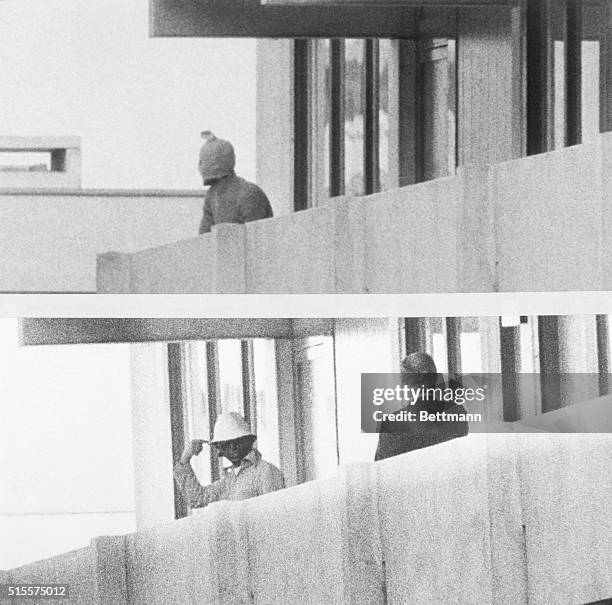 Member of the International Olympic Committee speaks with a masked PLO terrorist who invaded the Olympic Village, taking hostages and later killing...