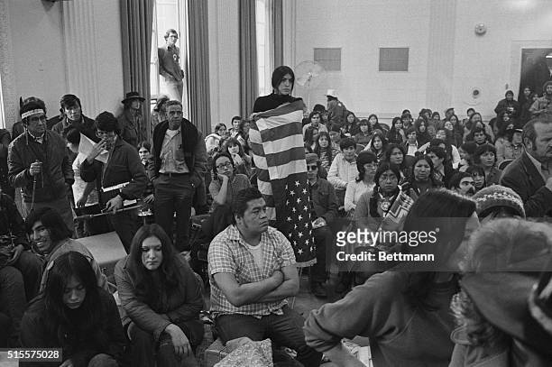 American Indian girl is wrapped in an upside down American flag as she and a group of about 500 American Indians occupy an auditorium 11/2 at the...