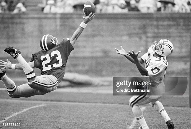Harvard's Bill Emper sails through the air to knock the ball away from Dartmouth's Jimmie Solomon who waits with outstretched hands during 2nd...