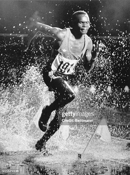 Kenyan Henry Nomo runs through water after completing a hurdle in the 3000 meter steeple chase at the 1976 Olympics in Montreal.