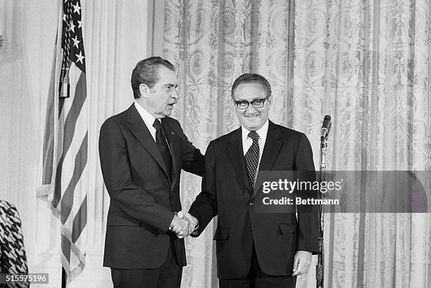 Washington: Pres. Nixon congratulates Henry Kissinger after he was sworn in as secretary of state 9/22 in a ceremony in the East Room of the White...