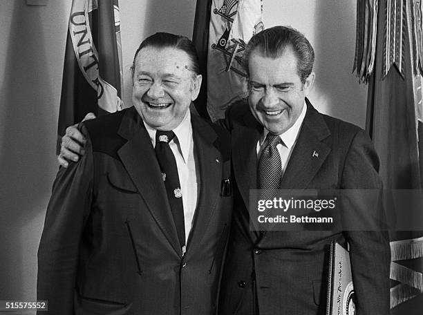 Pres. Nixon embraces country music entertainer Tex Ritter at the White House 12/14. The President accepted from a Ritter a special recording "in...