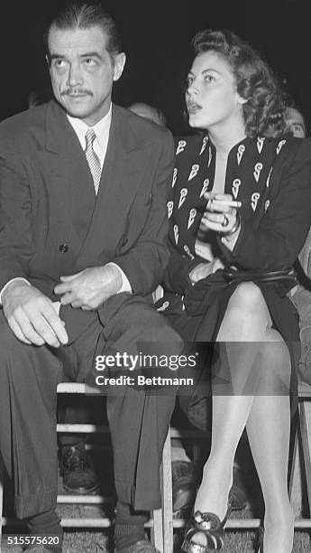 Movie producer and aviation executive Howard Hughes and Ava Gardner are shown at ringside during the title bout between Heavyweight champion Joe...