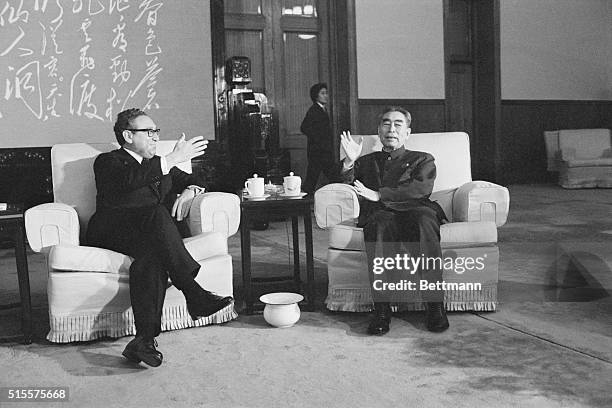 Henry Kissinger and Zhoi Enlai relax on large chairs at a reception given in the Great Hall of the People, after Kissinger's successful shuttle...