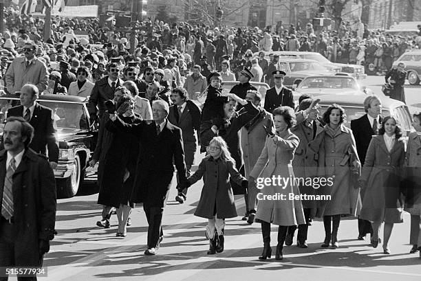 Amy Carter holds the hands of her parents President and Mrs. Jimmy Carter during the 1977 inaugural parade.