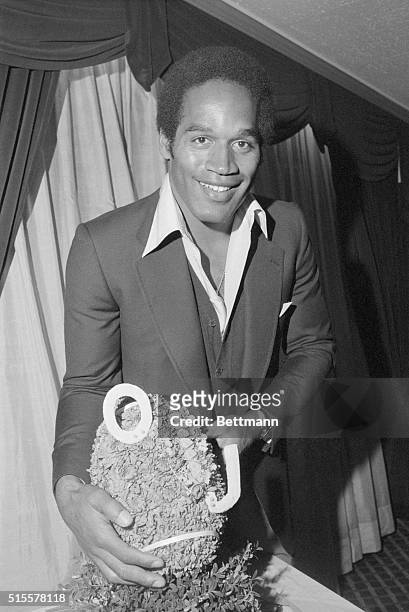 Football player O.J. Simpson poses with a football given to him at a luncheon by the Hertz Corporation to announce he has signed a new three-year...