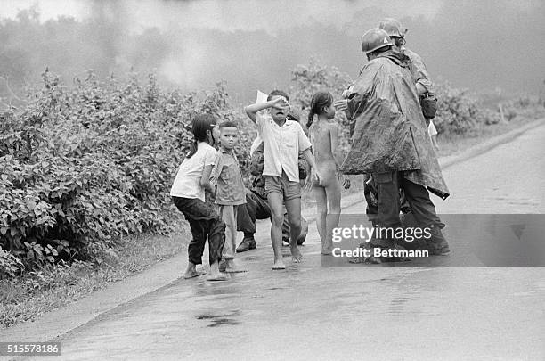 Trang Bang, South Vietnam: A Vietnamese girl has her eyes treated and a crying boy covers his eyes as he is treated June 8 after accidental napalm...