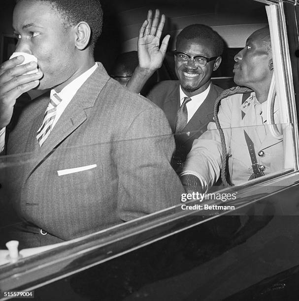 New York: Seated in a car Congolese Premier Patrice Lumumba flashes a big smile and waves as he leaves Idlewild Airport for Manhattan, following his...