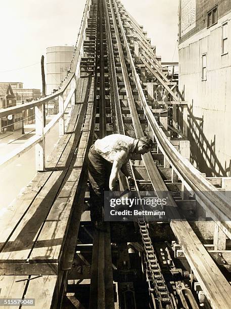 New York, NY: Greasing chaindrive of loop the loop "Cyclone" at Coney Island. Photo, ca. 1910.