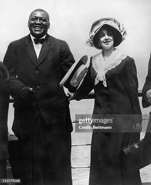 Jack Johnson : American heavyweight boxer with his wife on board a ship. 3/4 Lgth photo.