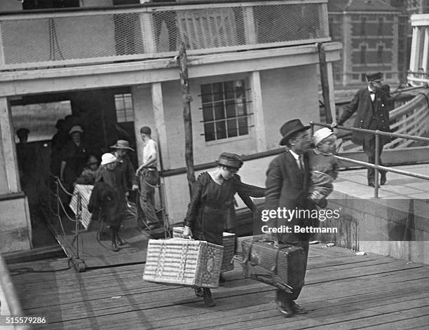 New York, NY: Immigrants leaving a barge at Ellis Island after inspection. Photograph.