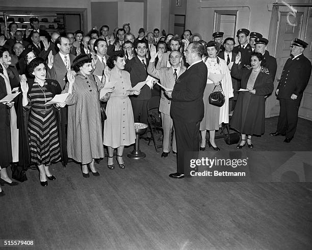 New York, NY: The oath of loyalty was administered to 80 members of the Metropolitan Opera Chorus by Grover Whalen Coordinator of Recruiting and...