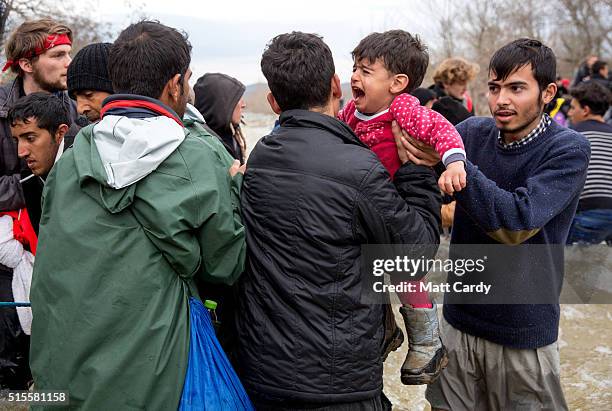 Migrants try to cross the river after leaving the Idomeni refugee camp on March 13, 2016 in Idomeni, Greece. The decision by Macedonia to close its...