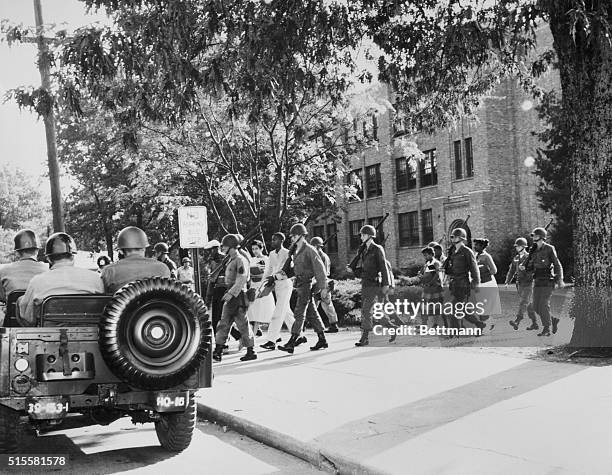 Members of the 101st Airborne escort black students away from a quiet Central High School at the end of the day.