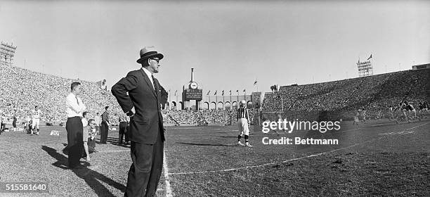 Los Angeles, CA: Chicago Bears coach George Halas whose habit of straying along the sidelines has caused a great deal of comment this seaason watches...