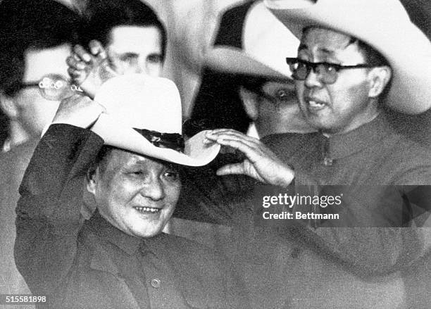 Simonton, Texas: With the help of an aide, Teng Hsiao-Ping, tries on a cowboy hat presented to him at a rodeo 2/2 near Houston. PH: Brent Frerck