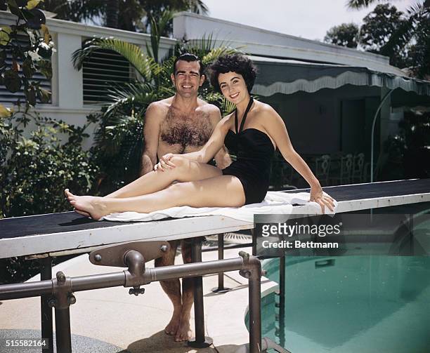 William D. Pawley, Jr. And his fiancee, 17-year-old Elizabeth Taylor, relaxing poolside in summer 1949 at the Miami Beach home of Pawley's father, a...