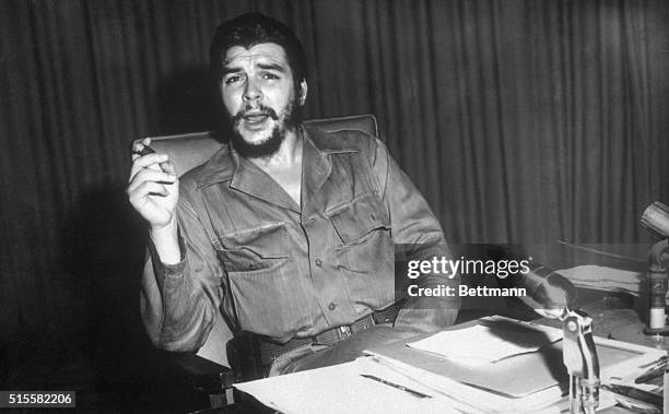 Portrait of Ernesto "Che" Guevara, Cuban revolutionary leader, sitting at a desk.