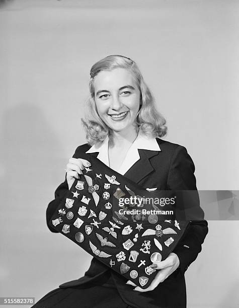 Shreveport, LA: Helen Reed, pretty Delta Air Lines agent at the Shreveport Airport, displayed outsized handbag decorated with 54 service insignia,...