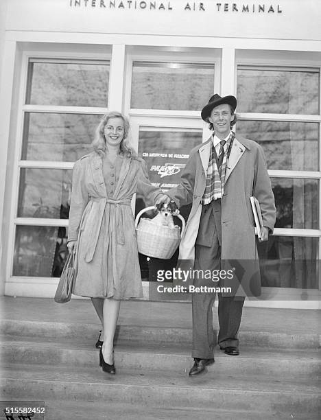 Shakespearean actor John Carradine and his wife, the former Sonia Sorel, at Lockheed Airport in Burbank, California, to begin a bond tour. Note...